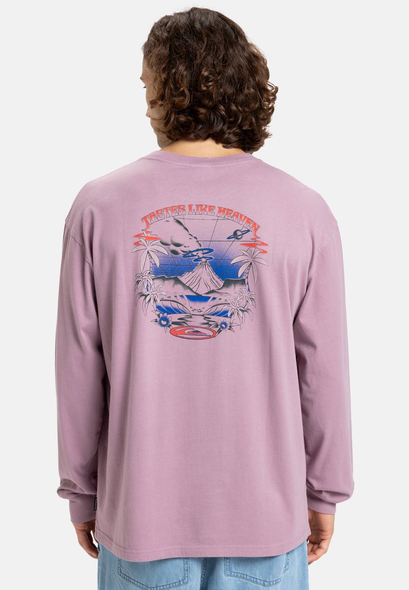 Langærmet, pastell-lilla t-shirt med en farverig grafisk design på ryggen med en vulkan, palmetræer og teksten "Smager som himlen."