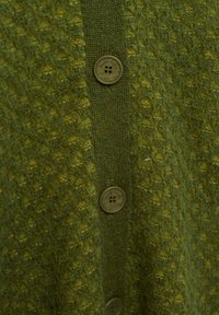 Cardigan verde testurizzato con chiusura a bottoni frontale composta da quattro bottoni marroni, con patta a coste e superficie morbida e lavorata a maglia.