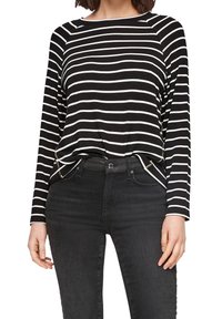 Schwarz-weiß gestreiftes Langarmshirt mit Rundhalsausschnitt, weichem Stoff und lockerer Passform, kombiniert mit schwarzen Jeans.