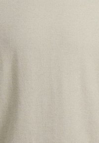 Tela de algodón beige con una textura suave y un sutil patrón tejido, dispuesto uniformemente por toda la superficie. Sin costuras visibles ni adornos.