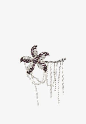 Épinglette en argent en forme de fleur ornée de rhinestones violets et transparents, avec des chaînes pendantes de longueurs variées et des détails scintillants.