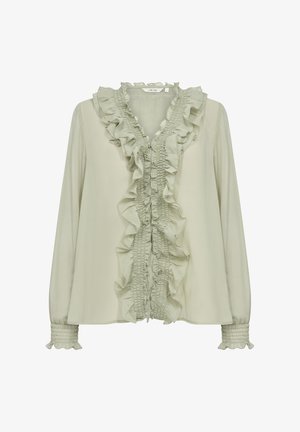 Hele roheline pluus, millel on volangiga esikülg, smockitud varrukalõpp ja tekstureeritud kangas. Disain sisaldab kihilise volangiga dekoltee.