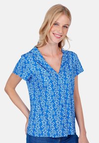 Short-sleeve blue blouse with white floral pattern, V-neckline, lightweight fabric, and slightly tailored fit.