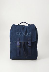 Mochila de mezclilla azul marino con solapa plegable, logotipo "REPLAY" en relieve, correas ajustables y dos cierres delanteros con hebilla.