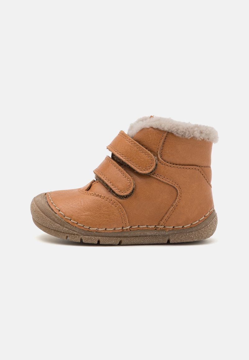 Bottine en cuir marron avec une doublure en fourrure blanche douce, double bandes Velcro et une semelle en caoutchouc texturée conçue pour l'adhérence.