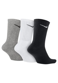 Trois paires de chaussettes de sport en gris, blanc et noir, dotées d'une texture côtelée et d'un petit logo Nike noir près du haut.