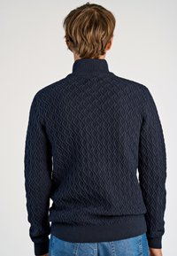 Marineblauwe gebreide trui met een gestructureerd ruitpatroon, ribgebreide kraag en manchetten, met een getailleerd ontwerp dat geschikt is voor casual kleding.