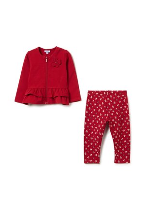 Rote Zip-Jacke mit rüschensaum und Blumenmotiv, kombiniert mit roten Leggings, die kleine weiße Blumenmuster aufweisen. Weiches Material, lässiges Design.