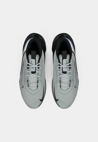 Pelni pelni pelēki un melni sporta apavi ar auklēm, skatīti no augšas uz balta fona.