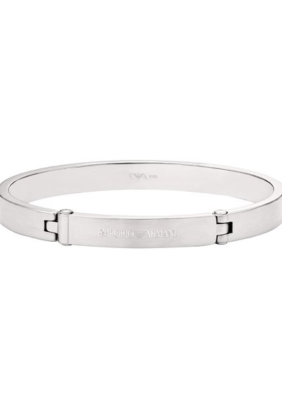 Bracelet en métal argenté avec un design plat et épuré. Présente un branding gravé sur la fermeture et une texture lisse, mettant en valeur un style minimaliste.