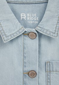 Light blue denim shirt featuring a standard collar, two buttons, and "BLUE RIDGE" branding stitched in white on the inside label.