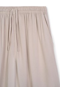 Pantaloni beige con vita elastica e cordoncino regolabile, dotati di tasche laterali e una trama di tessuto liscia e leggera.