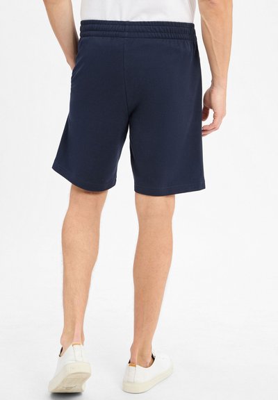 Shorts bleu marine avec une taille élastique, fabriqués à partir d'un tissu lisse, dotés de poches latérales et d'une coupe décontractée.