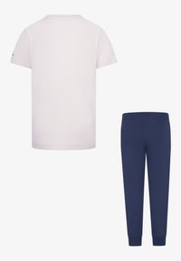 Short-sleeve, crew-neck t-shirt in light beige, paired with navy blue elastic waist pants. Both made from soft, breathable fabric.