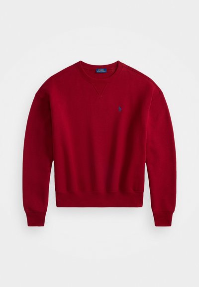 Sweatshirt vermelho de gola redonda com punhos e bainha canelados, apresentando um pequeno logótipo bordado azul no lado esquerdo do peito.