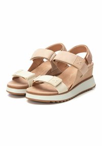 Sandalias de cuña beige con dos correas ajustables, un acento texturizado en la parte superior, una plantilla acolchada y una suela blanca contrastante.