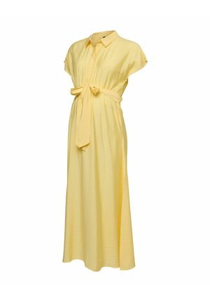 Gelbes Umstandskleid mit kurzen Ärmeln, Kragen, Knopfleiste vorne und Taillengürtel, das bis zum Knöchel reicht.