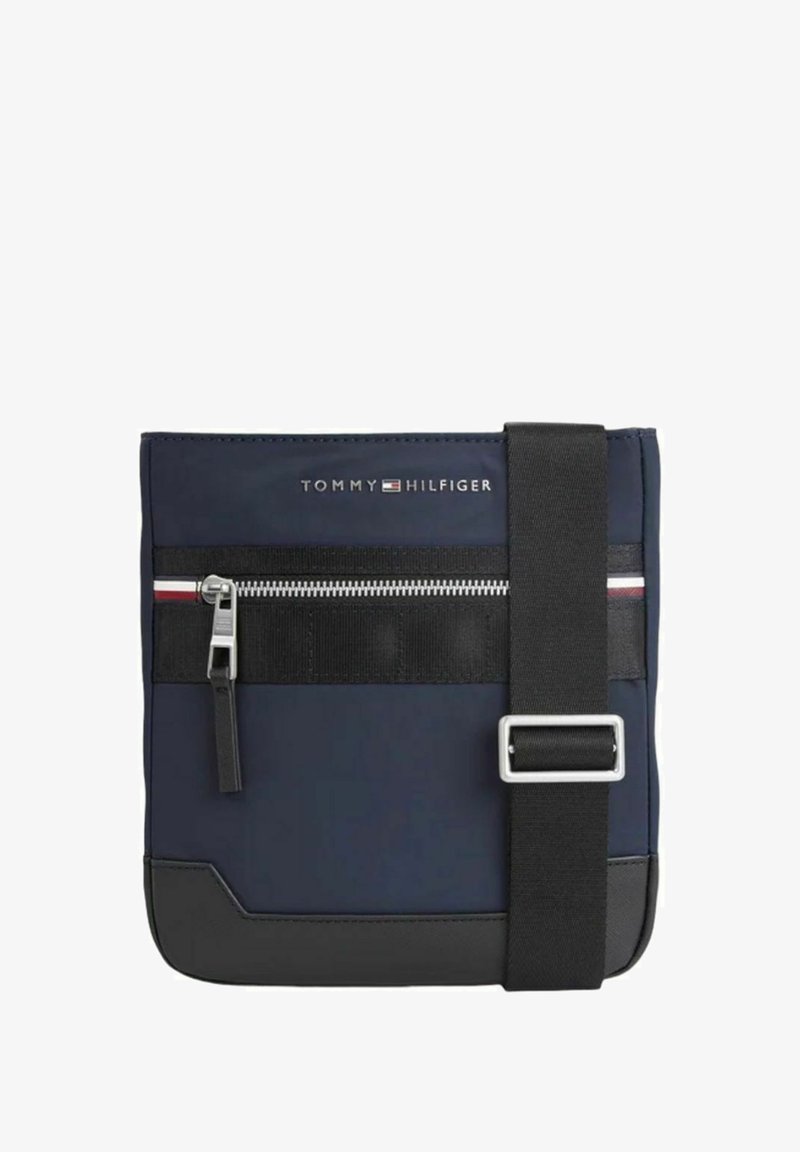 Borsa a tracolla blu navy realizzata in un tessuto liscio, con una tasca con zip nera, dettagli in argento e una tracolla regolabile. Presenta il logo sulla parte anteriore.