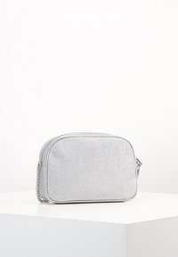 Borsa a tracolla argento con finitura testurizzata, forma rettangolare, bordi arrotondati e tracolla a catena. Presenta una chiusura zipper.