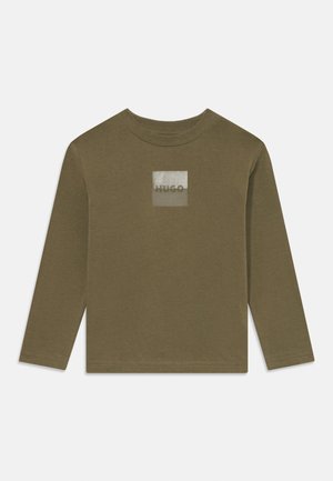 Oliven grønn langermet T-skjorte laget av myk bomull, med en kvadratisk logo i sølv med teksten "HUGO" sentrert. Regular fit og rund hals.