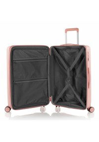 Hartschalentrolley in hellrosa. Das Innere ist mit grauem Stoff ausgekleidet und verfügt über Reißverschlussfächer, Kreuzgurte zur Befestigung der Gegenstände und glatte Rollen.