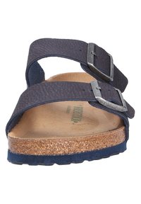 Sandale bleu marine à deux brides avec un matériau texturé, des boucles en argent, une semelle en liège et une semelle de couleur bleu foncé, conçue pour le confort et le soutien.