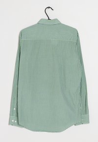 Langærmet skjorte i grønt og hvidt tern med knapmanchetter, lige krave og bøjle til udstilling. Ingen synlige detaljer på forsiden.