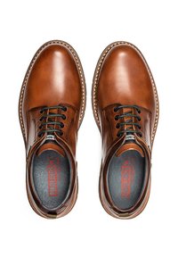 Zapatos de cuero marrón con un acabado suave, punta redondeada, costuras en contraste y cordones negros. El interior cuenta con una suela acolchada con el logotipo.