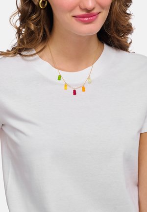 Halskette in Goldton mit fünf bunten Gummibärchen-Anhängern in Grün, Gelb, Orange, Rot und Lila, getragen über einem weißen T-Shirt.