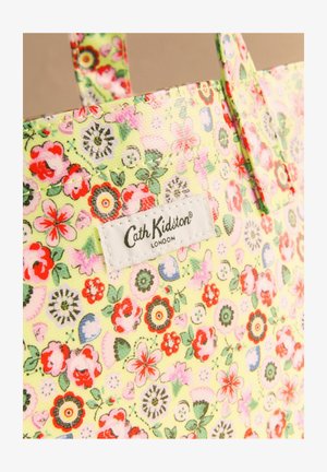 Virágmintás sárga táska piros, rózsaszín, zöld virágokkal, fehér, téglalap alakú Cath Kidston London felirattal a felső szélénél, fogantyúval látható.
