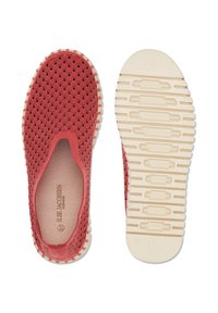 Rode instapschoenen met een gegolfd patroon, een beige textuurrijke zool en een zichtbaar merknaamlabel aan de binnenkant van de schoen. Eén schoen toont de bovenkant, de andere de zool.