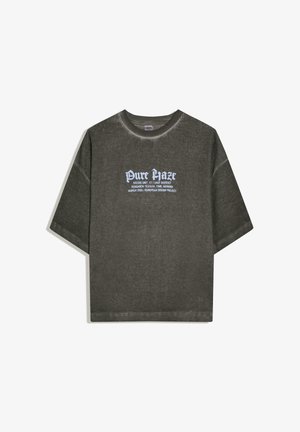 Dunkelgraues, geripptes T-Shirt mit kurzen Ärmeln und weißem Text "Pure Haze" sowie kleinerem Aufdruck, der auf ein europäisches Designprojekt zum Thema Textur und Erinnerung verweist.