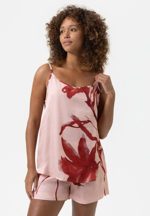 Débardeur en soie à fleurs de couleur rose pâle, orné de motifs de fleurs rouges et doté de fines bretelles, associé à un short rose assorti.