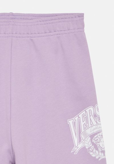 Παντελόνι φόρμας λιλά με απαλό ύφασμα, ελαστική μέση και λευκά γραφικά κείμενα και σχέδιο σε ένα πόδι.