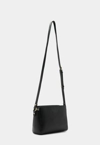 Sort læder crossbody taske med tekstureret overflade, rektangulær form, justerbar rem og hardware detaljer i guld-tone.