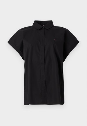Chemise noire à manches courtes avec un col plié, dotée d'une patte de boutonnage à l'avant et d'un petit logo sur le côté gauche de la poitrine.