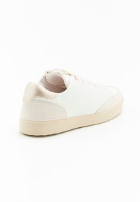 Sneaker bianca con una toma in pelle liscia e un cappuccio in camoscio sul tallone, suola in gomma beige e lacci in tonalità. Dettaglio con zip sul retro.