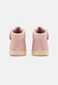 Rosa High-Top-Sneaker aus glattem Leder mit strukturierten Stoffakzenten. Cremefarbene Sohlen und Klettverschlussdetails auf der Rückseite.