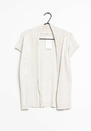 Helle beige Strickjacke aus Strickstoff, mit Kurzärmeln, gerippter Textur und einer Vorderöffnung mit dekorativen Nähdetails.