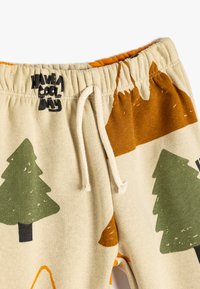Tan sweatpants med grønne træer og brune bjerge. Elastisk talje med hvid snor og trykt logodesign.