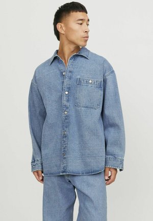 Jeansjacke in Hellblau mit Kragen, Fronttasche und silbernen Druckknöpfen. Gewebter Stoff mit lockerer Passform und überschnittenen Schultern.