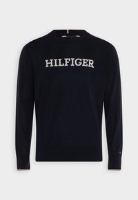 Maglione blu navy realizzato in un tessuto morbido, con collo a giro e maniche lunghe. Logo "HILFIGER" in bianco sul petto. Accenti rossi e bianchi.