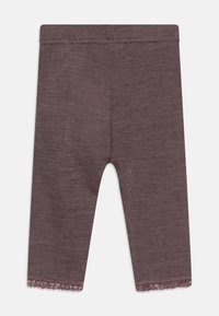 Leggings maro dintr-un material tricotat moale, având o margine dantelată ondulată la tiv și un model texturat pe întreaga suprafață.
