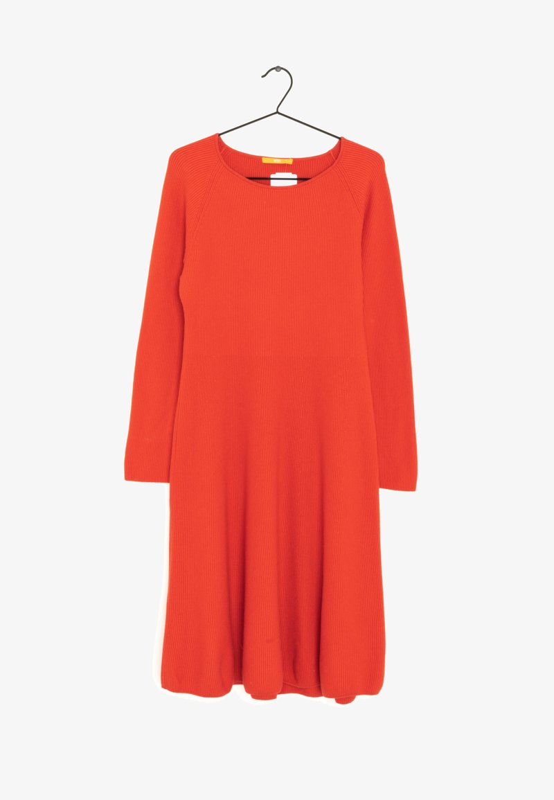 Robe en maille orange à manches longues et longueur au genou, avec col arrondi, suspendue à un cintre noir sur fond blanc.