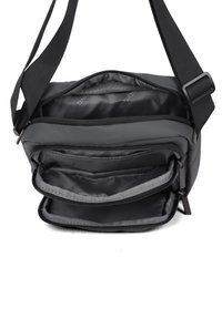 Borsa messenger nera con tracolla regolabile, scomparto principale con zip e due tasche interne, realizzata in un tessuto resistente con una texture liscia.