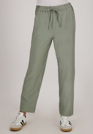 Lichtgroene, lichte broek met een elastische tailleband en een trekkoord. Rechte broekspijpen met een gestructureerde stof. Gecombineerd met witte sneakers.