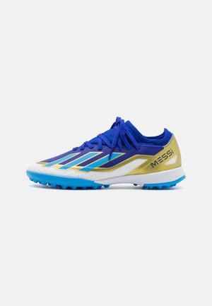 Scarpe da calcio blu con un design bianco, oro e blu. Presentano strisce angolate, una tomaia testurizzata e tacchetti in gomma per una migliore trazione.