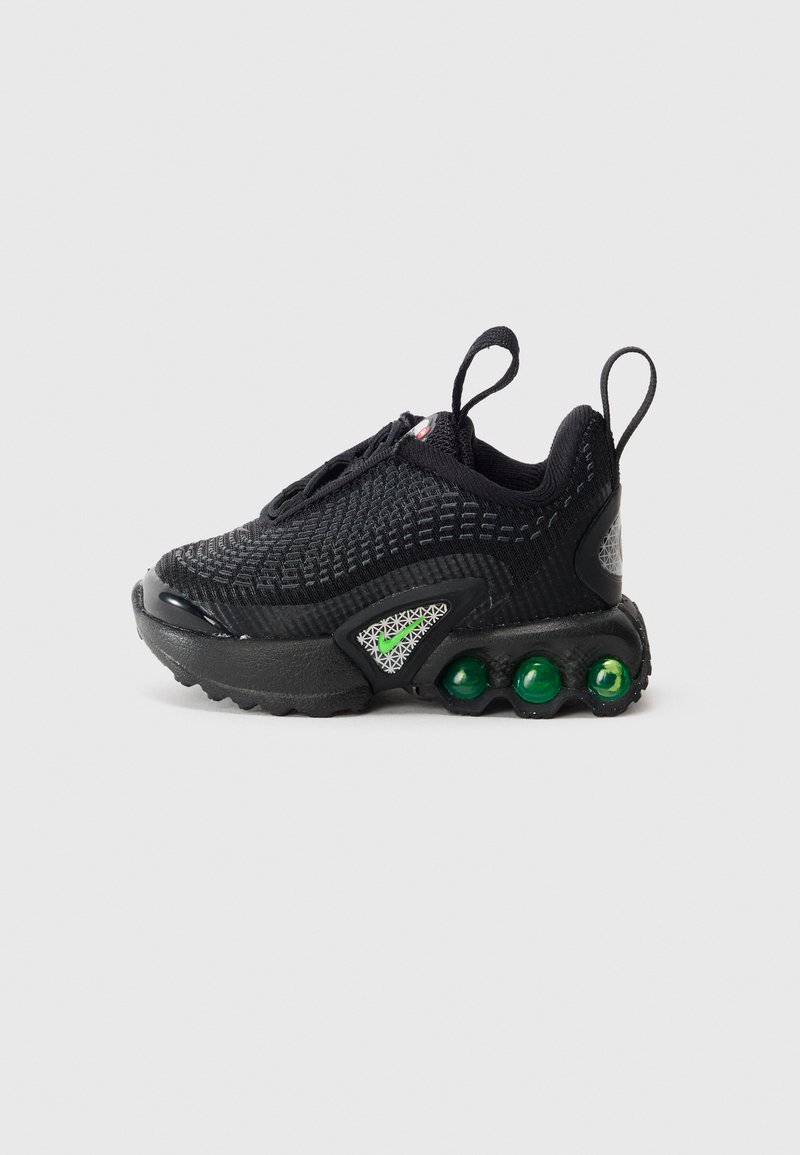 Sapatilha atlética preta com parte superior em malha, destaques verdes e três cápsulas de amortecimento verdes visíveis na sola, apresentada do lado externo.