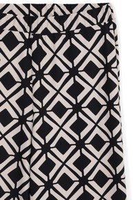 Pantalons noirs et beiges avec un motif géométrique abstrait comportant des formes de diamant et de X interconnectées.