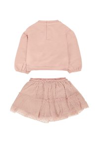 Maglietta lunga rosa chiaro con chiusura a bottone sul retro abbinata a una gonna tutu a strati con una texture a motivo.